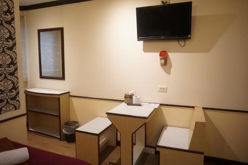 a room with two tables and a tv on the wall at Honey House1 hotel in Bangkok