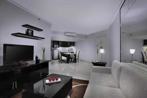 a living room with a couch and a tv at Horison Ultima Suite & Residences Rasuna Jakarta in Jakarta