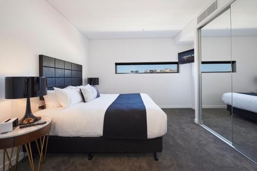a bedroom with a large bed and a desk and a bed sidx sidx sidx sidx at Silkari Suites at Chatswood in Sydney