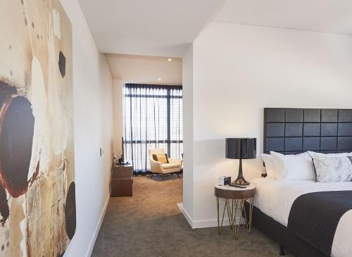 a hotel room with a bed and a chair at Silkari Suites at Chatswood in Sydney