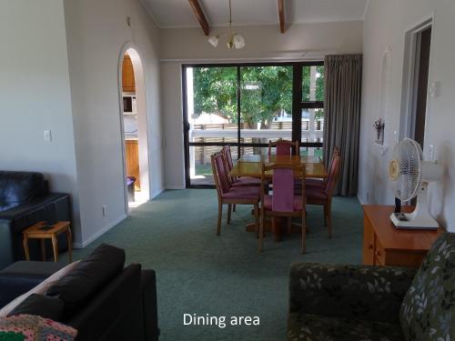 a living room with a table and chairs and a dining area at Cabourne Cottage in Hamilton