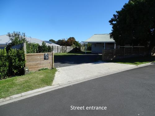 a street entrance with a fence and a house at Cabourne Cottage in Hamilton