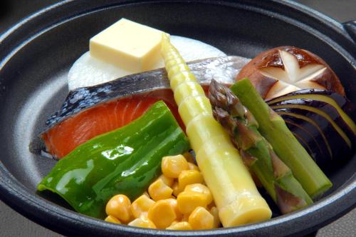 a plate of food with meat vegetables and cheese at Sunhills Sarai in Shintotsukawa
