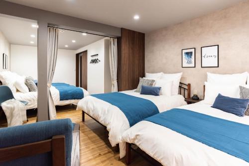 a hotel room with two beds and a mirror at Harbor Light Tengachaya in Osaka