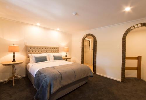 a bedroom with a large bed and a mirror at The Manor Basket Range in Basket Range