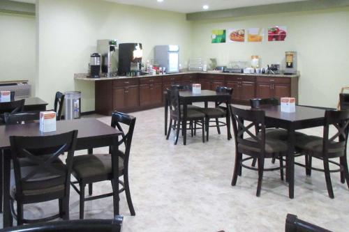a restaurant with tables and chairs and a kitchen at Quality Inn in Longmont