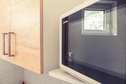 a television sitting on a shelf in a kitchen at Sekli Panzió in Balatonlelle