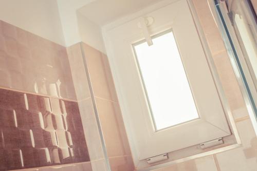 a window on a wall in a bathroom at Sekli Panzió in Balatonlelle