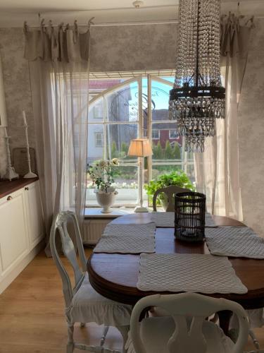 a dining room table with chairs and a large window at The Piano Shop in Gränna