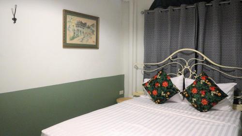a bedroom with a bed with two pillows on it at The Neighbors Hostel in Phuket Town