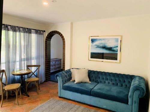 a living room with a blue couch and a table at The Manor Basket Range in Basket Range