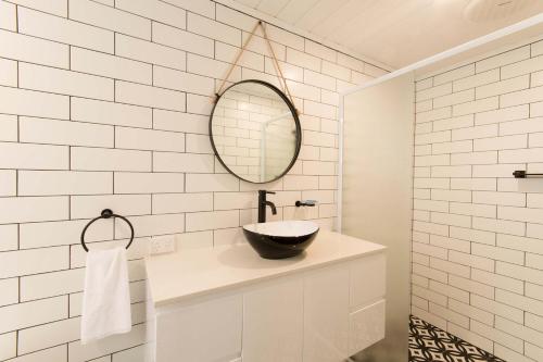ein Bad mit einem Waschbecken und einem Spiegel in der Unterkunft The Manor Basket Range in Basket Range