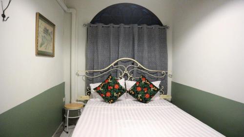 a bedroom with a bed with two pillows on it at The Neighbors Hostel in Phuket Town