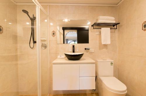a bathroom with a sink and a toilet and a shower at The Manor Basket Range in Basket Range