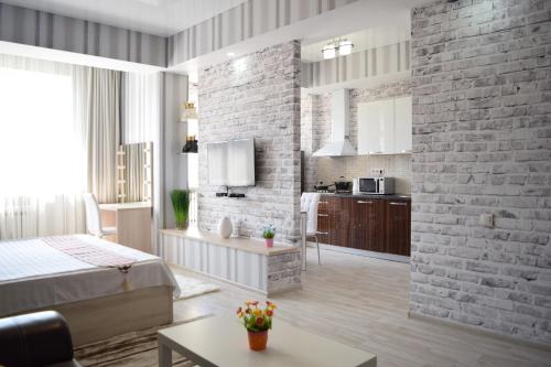 una camera da letto con un muro di mattoni e un letto e una cucina di FlatRent apartment a Bishkek