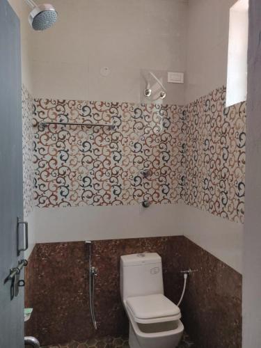 a bathroom with a toilet and a wall at Trippr Chikkamagaluru in Chikmagalūr