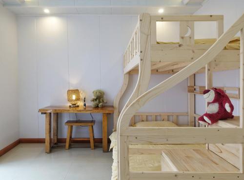 a bedroom with a bunk bed with a table and a desk at Xingping Our Inn in Yangshuo