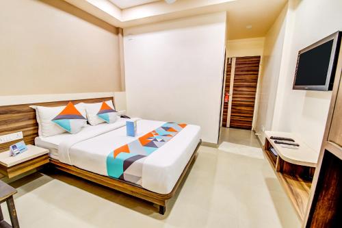 1 dormitorio con 1 cama grande y TV en Hotel Dreamland en Lonavala