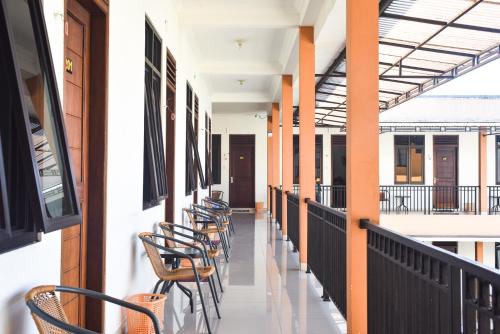 a row of chairs on a corridor of a building at RedDoorz near Alun Alun Wonosobo in Wonosobo