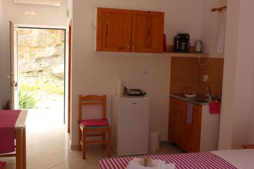 una pequeña cocina con nevera y mesa en Aaron Studios Apartments, en Agia Fotia