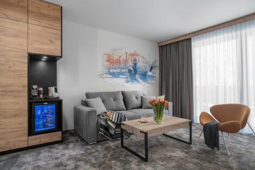 uma sala de estar com um sofá e uma televisão em Rezydencja Morski Tygiel em Leba