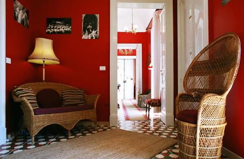a living room with red walls and wicker chairs at 5 Balconi B&B in Catania