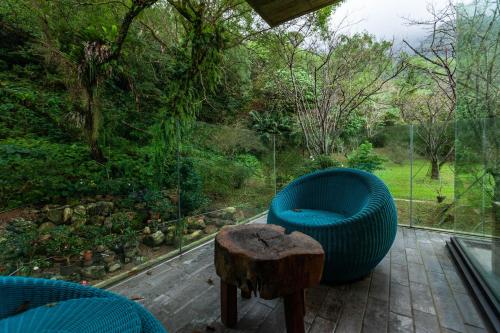 a blue chair and a wooden stump on a patio at Echovilla B&B II in Hualien City
