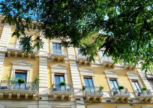 un edificio giallo con balconi e piante in vaso di 5 Balconi B&B a Catania