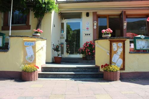 a building with stairs and flowers in front of a door at Hotel Café Post in Rüdesheim am Rhein