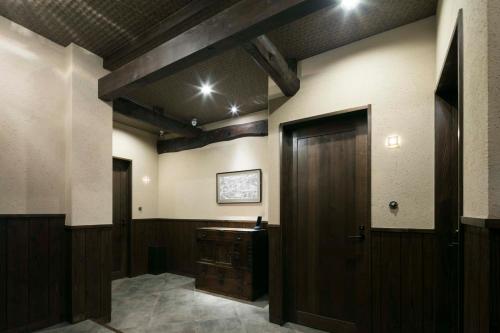 a room with a wooden door and a desk at Arima Koyado Uraku in Kobe