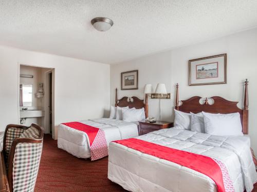 Habitación de hotel con 2 camas con sábanas rojas y blancas en OYO Hotel San Antonio East, en San Antonio
