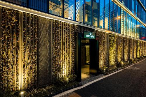 a building with a sign on the side of it at Hotel Resol Yokohama Sakuragicho in Yokohama