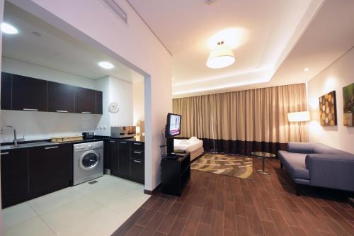 a living room with a couch and a washing machine at SHH -Furnished Studio Apartment in Matrix Tower, Sports City in Dubai