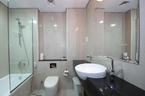 a bathroom with a sink and a toilet and a shower at SHH -Furnished Studio Apartment in Matrix Tower, Sports City in Dubai