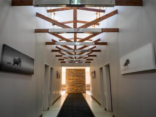a hallway with a ceiling with wooden beams at Hotel @ Secunda in Secunda
