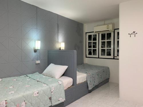 a bedroom with two twin beds in a room at At Night in Chumphon