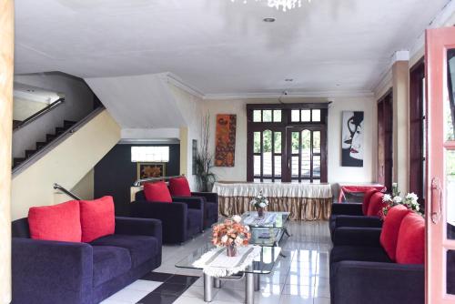 a living room with blue couches and red pillows at RedDoorz Plus @ Tirta Kencana Hotel in Ambon