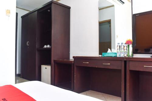 a bathroom with a large wooden vanity with a mirror at RedDoorz Plus @ Tirta Kencana Hotel in Ambon
