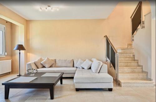 a living room with a couch and a coffee table at Villa Jullia & Rosa Vourvourou in Vourvourou