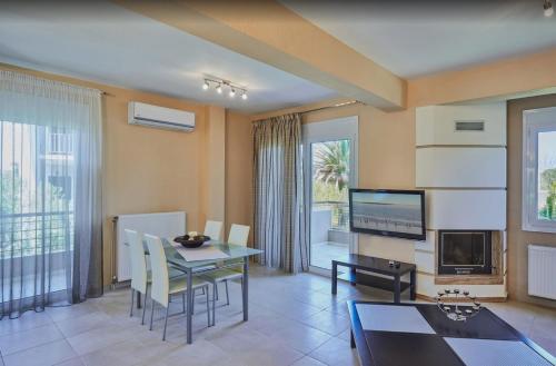 a living room with a dining table and a tv at Villa Jullia & Rosa Vourvourou in Vourvourou