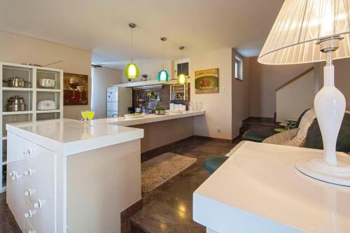 a kitchen and living room with a table with a lamp at Villa Skalinada - Pool, Sea View & Private Path to Beach I Baška Voda in Baška Voda