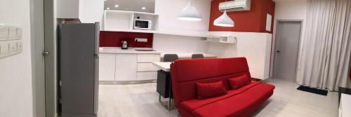 a red chair in a small kitchen with a red couch at Strait Garden Suites X Ace Pro @ George Town in Jelutong