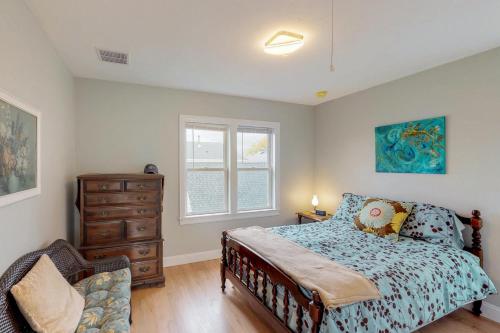 a bedroom with a bed and a dresser and a window at Bella Luna in Falmouth