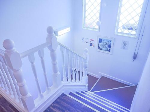 a staircase leading up to a balcony with a white door at Karuizawa Pension Sato no Nukumori in Karuizawa