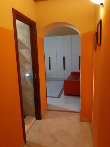 an orange hallway with a red couch in a room at Casa Parthenope in San Giorgio a Cremano