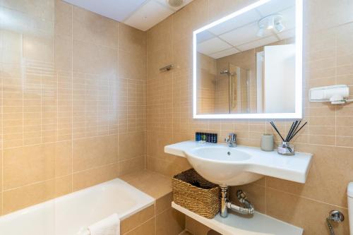 a bathroom with a sink and a tub and a mirror at Trendy Homes Almería in Almería