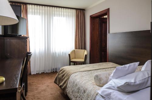 a hotel room with a bed and a television at Kormoran Medispa in Rowy