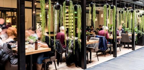 a group of people sitting at tables in a restaurant at Hotel Verso in Jyväskylä