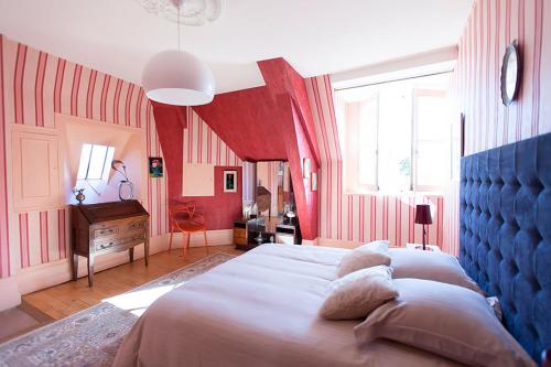 - une chambre avec un grand lit aux murs rouges dans l'établissement Chateau Marieville, à Bonneuil-Matours