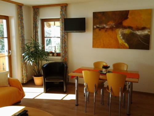 a dining room with a red table and yellow chairs at Ferienwohnungen Obex in Mieders